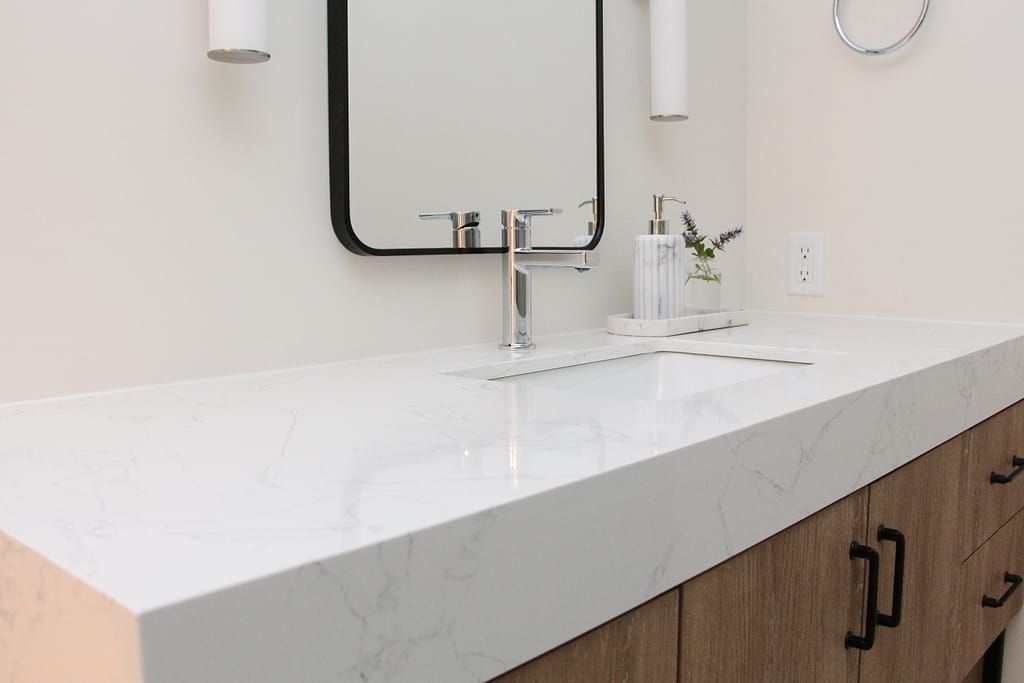 A MCM vanity in a warm basement bathroom with thick quartz top
