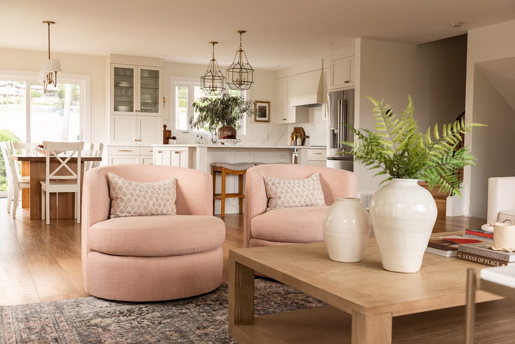 pink living room, swivel chairs, cream kitchen