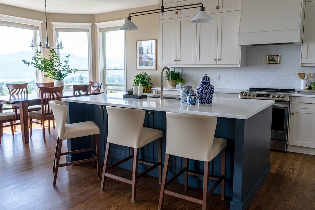 Transitional cream kitchen with navy island, modern island light