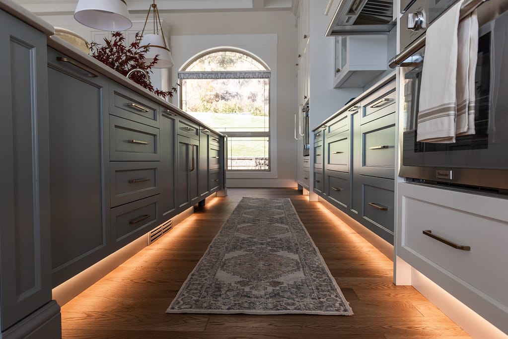 Toe Kick lighting in kitchen with accent french blue cabinetry and integrated Thermador appliances