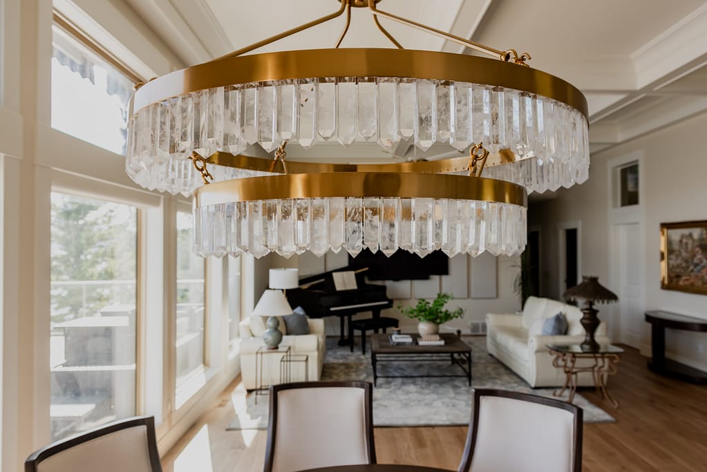 Warm brass chandelier with natural calcite crystal tiers, suspended in a dining space with 12-foot ceilings.