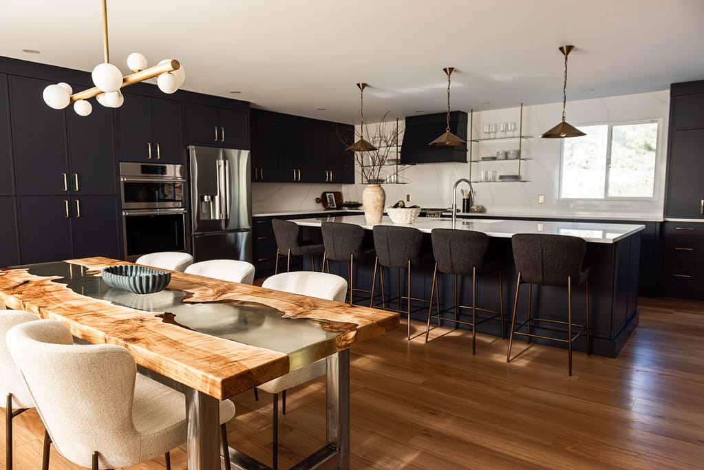 Bright renovated kitchen with large island, navy blue cabinetry, and warm wood accents in a family-focused home renovation