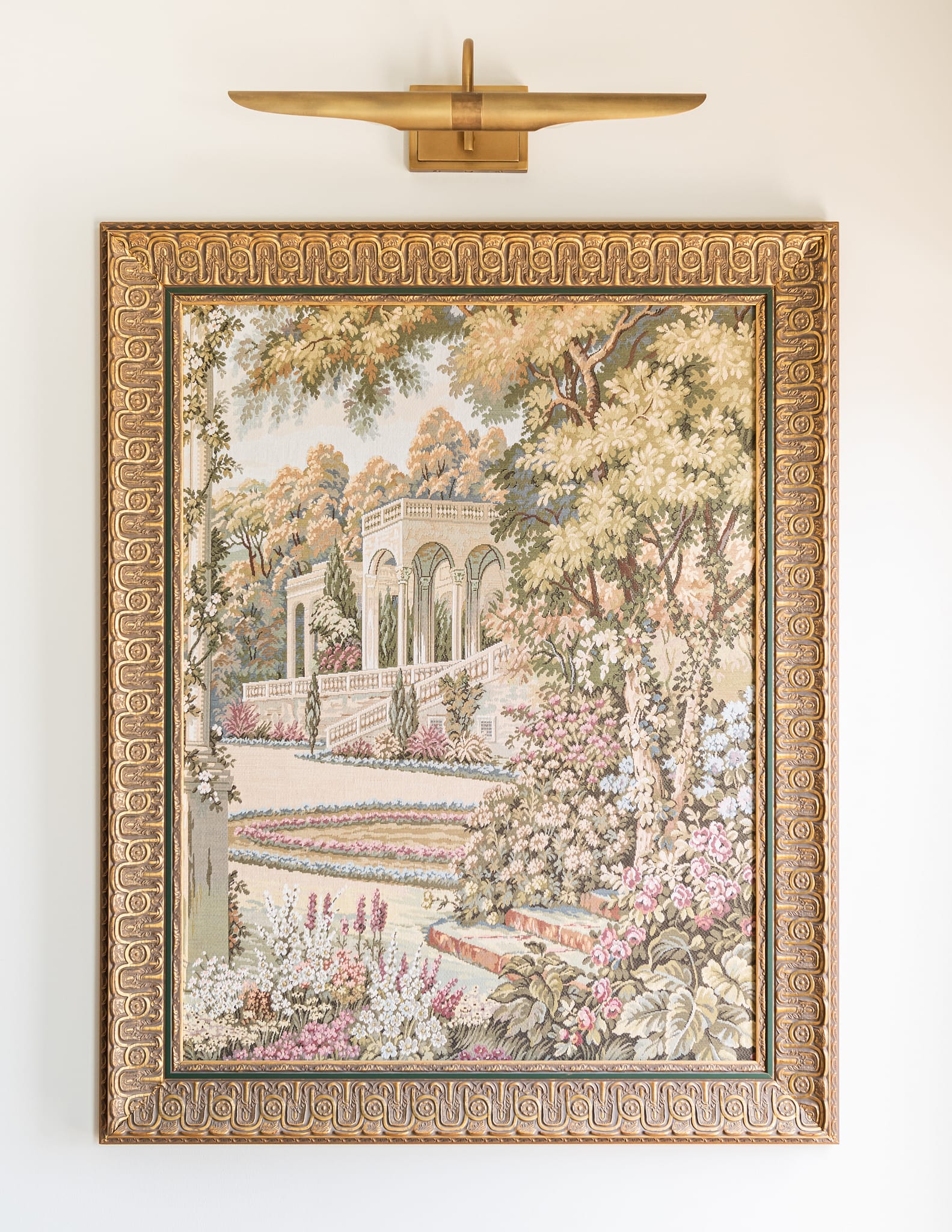 tapestry artwork in antique frame with gold art light