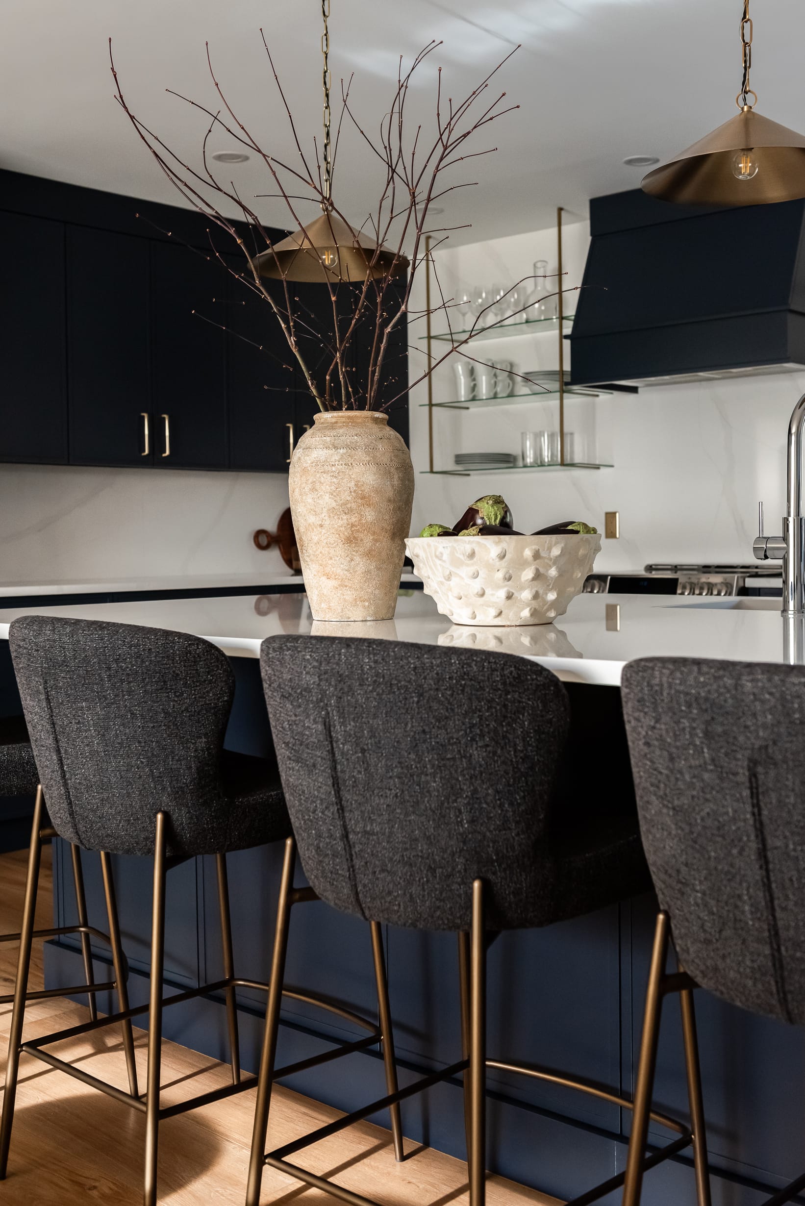 Bright renovated kitchen with large island, navy blue cabinetry, and warm wood accents in a family-focused home renovation