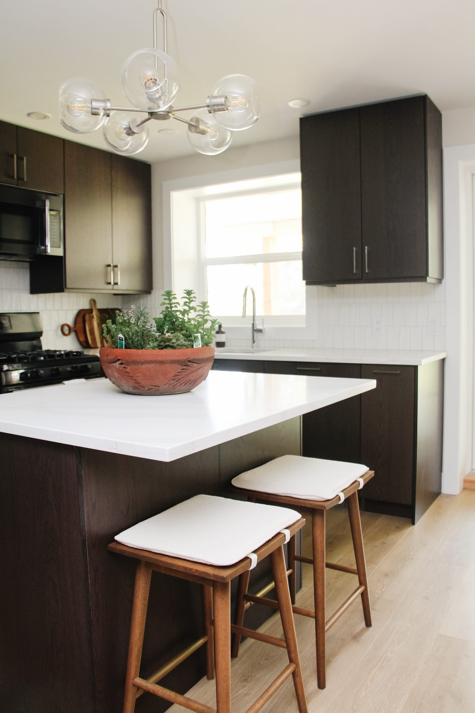 MCM basement suite kitchen, walnut veneer cabinets, quartz, vertical subway tile backsplash