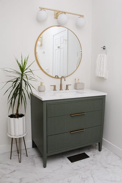 contemporary kids bathroom with green vanity and gold accents