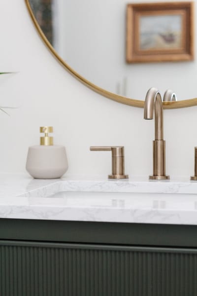 contemporary kids bathroom with green vanity and gold accents