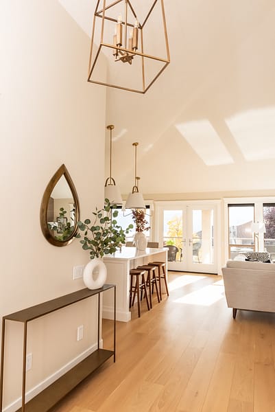 Entry with tall ceilings leading into open concept kitchen living, warm white