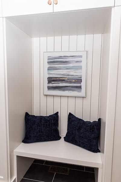 Cream mudroom cabinetry shiplap seating nook