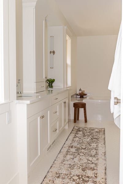 Traditional white vanity with linen tower and crown moulding