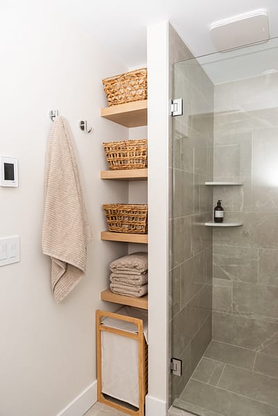 basement bathroom with open shelving and walk in shower