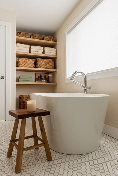 transitional primary ensuite, warm wood tones and white tile, stand alone tub under window