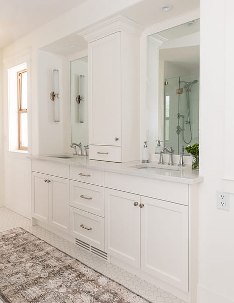 Traditional white vanity with linen tower and crown moulding
