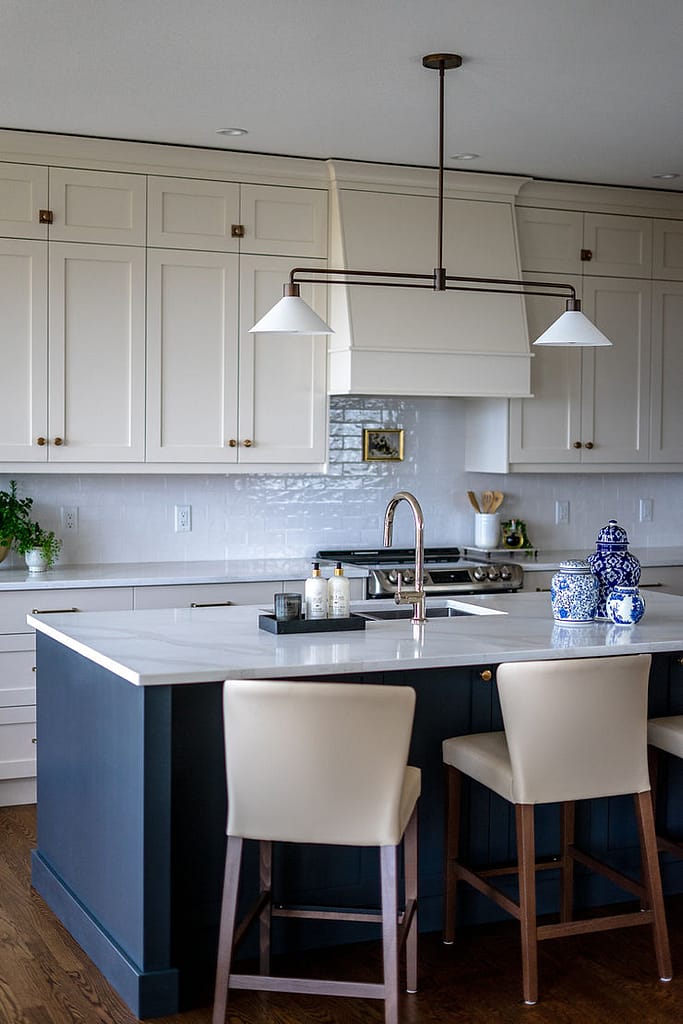 Transitional cream kitchen with navy island, modern island light