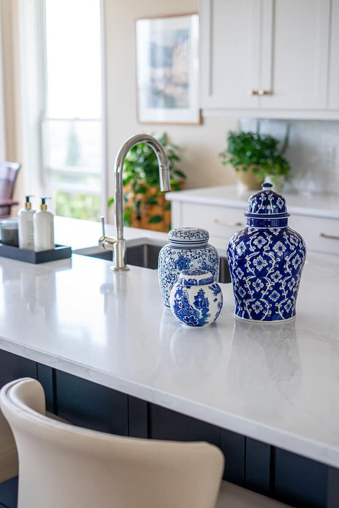 Transitional cream kitchen with navy island, modern island light