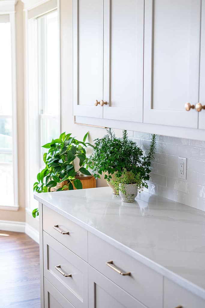 Transitional cream kitchen with navy island, modern island light