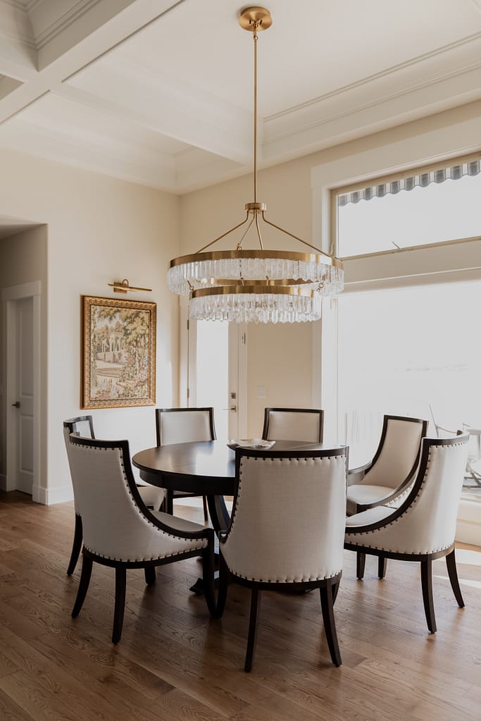 Warm brass chandelier with natural calcite crystal tiers, suspended in a dining space with 12-foot ceilings.