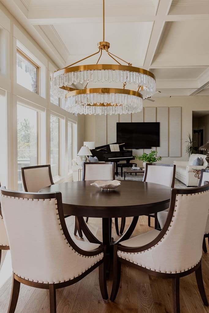 Warm brass chandelier with natural calcite crystal tiers, suspended in a dining space with 12-foot ceilings.