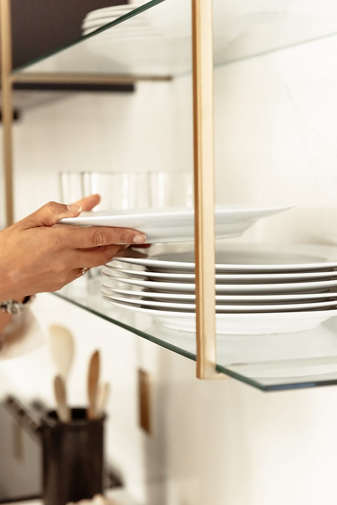 Women in bright renovated kitchen with large island, navy blue cabinetry, and warm wood accents in a family-focused home renovation