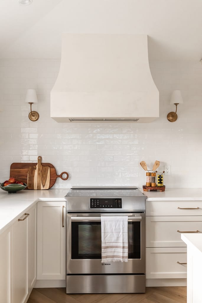 transitional cream kitchen, plaster hood, open brass shelves, tile to ceiling