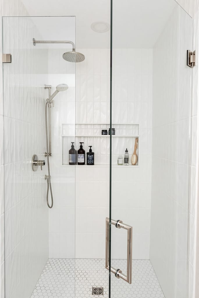 vertical textured subway tile shower, shower niche, glass shower enclosure