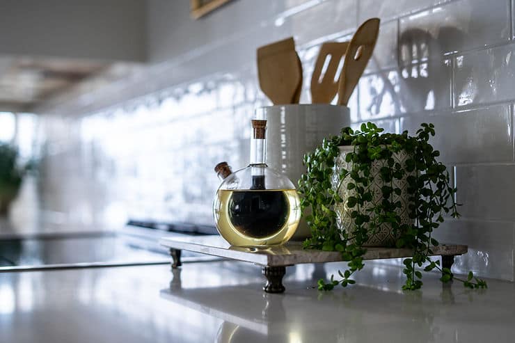 Transitional cream kitchen with navy island, modern island light