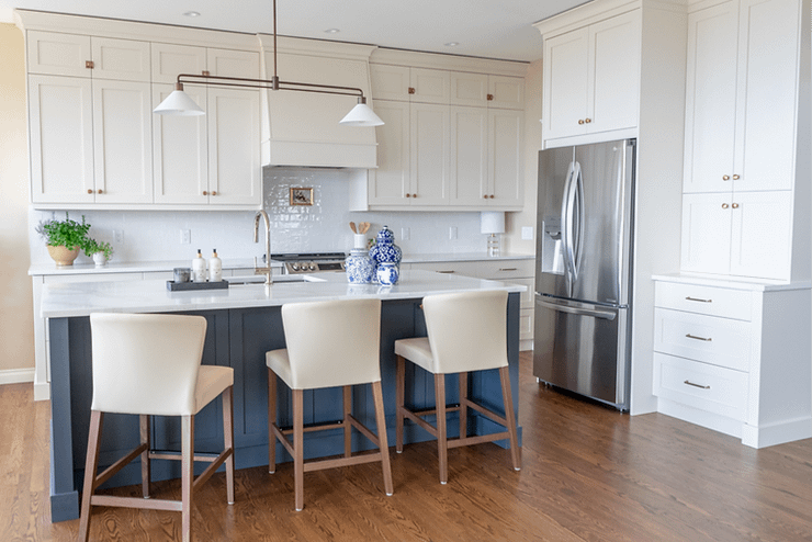 Transitional cream kitchen with navy island, modern island light