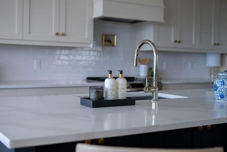 Transitional cream kitchen with navy island, modern island light