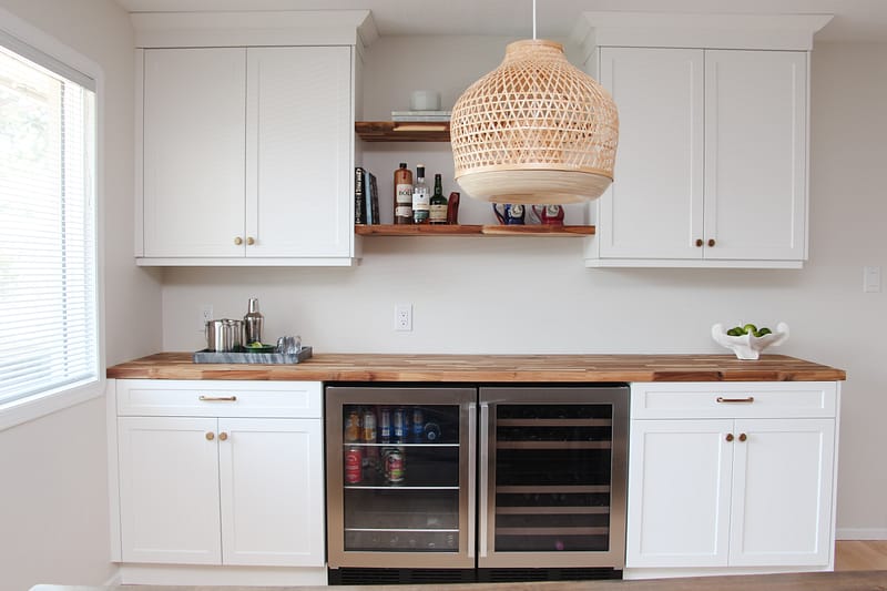 bar in dining room, white cabinets, butcher block countertop, floating wood shelves