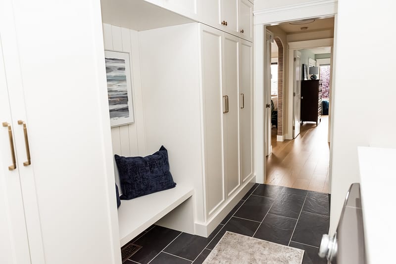 Cream mudroom cabinetry shiplap seating nook