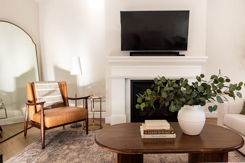 transitional living room cast stone fireplace, floor mirror