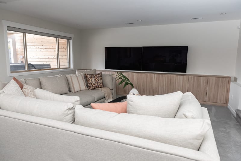 basement games room, sectional and coffee table styled, two TVs