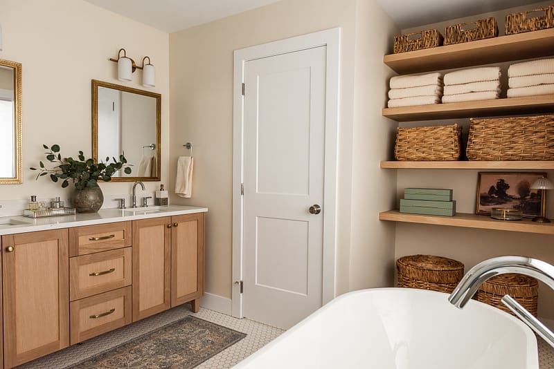 transitional ensuite with white oak vanity, vintage mirrors and open shelf styling