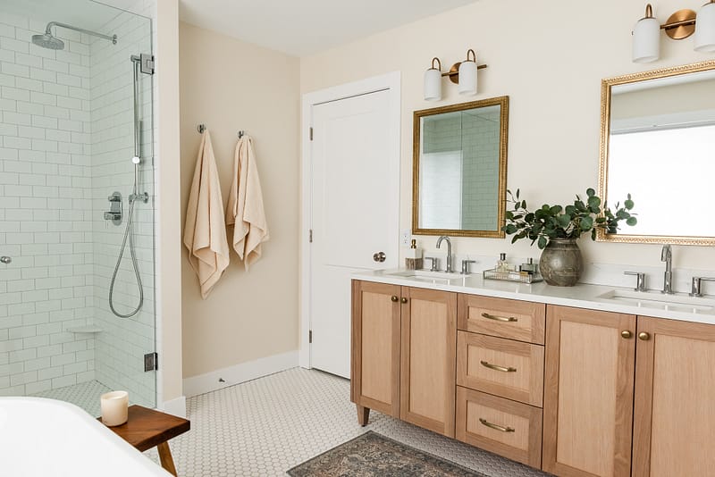 transitional ensuite with white oak vanity, vintage mirrors and styling