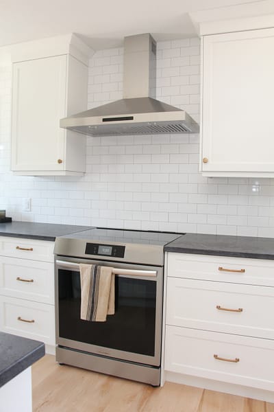subway tile to ceiling, chimney hood fan, classic white kitchen cabinets, timeless white kitchen