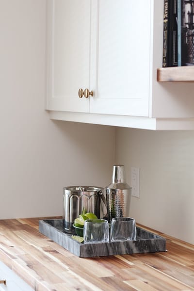bar in dining room, white cabinets, butcher block countertop, floating wood shelves