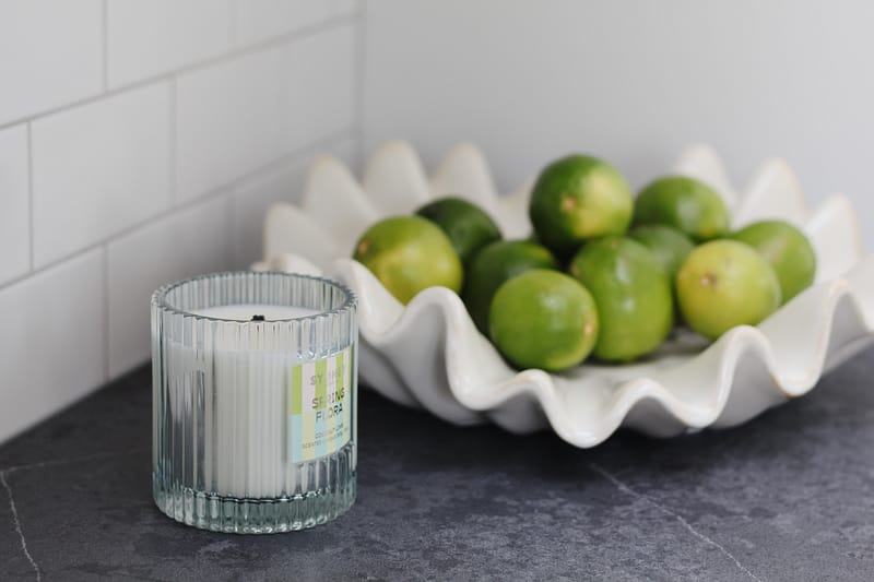 kitchen styling, bowl of limes, fluted candle, black quartz countertop, subway tile backsplash